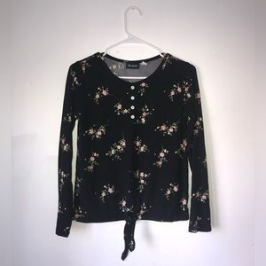This is a black shirt with flowers decorating it the brand is children’s place